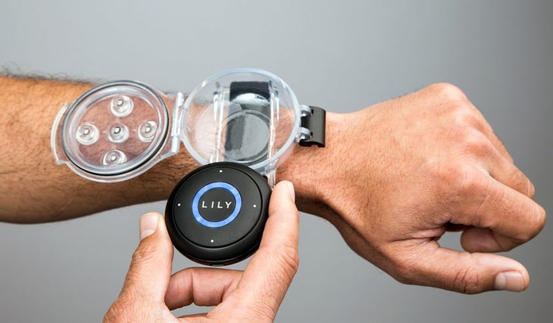 Lily Camera 隨機附送圓形的 GPS 定位器，搭配特製的保護殼和腕帶，可如手錶般戴在腕上。。