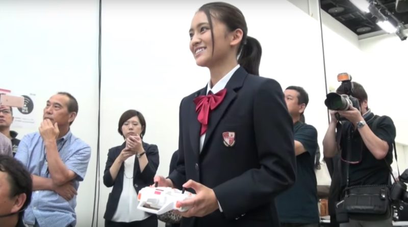 記者會當天更找來 16 歲青春女星岡田結實當嘉賓，她首次操控航拍機表現興奮。（翻攝自 YouTube／Oricon）